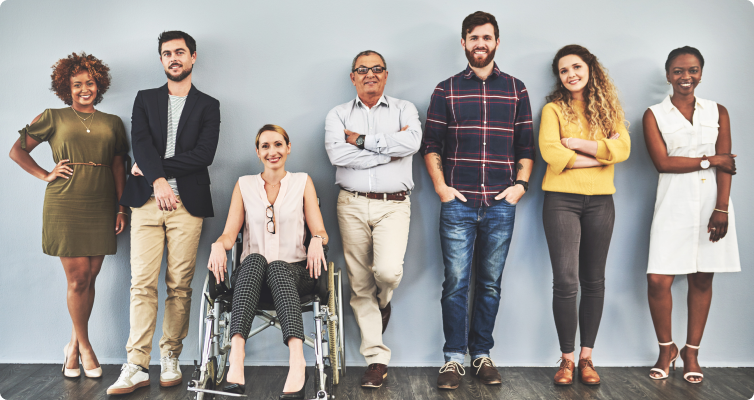 A diverse range of people pose against a grey background