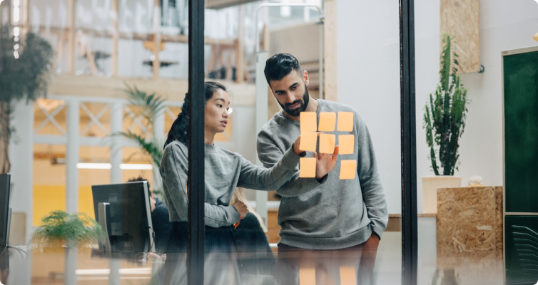 Two women have a discussion while standing in an office