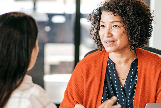 Two women have a discussion in an office